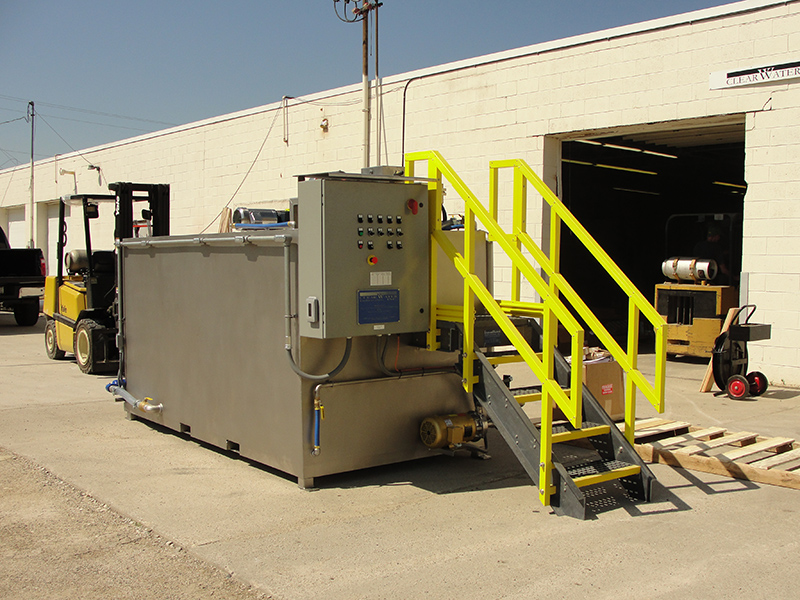 Sistema de preparación de polímeros Modelo 800 Stainless Steel de Clearwater Industries mostrando el panel de control y la escalera del operador para alimentar el polímero seco.