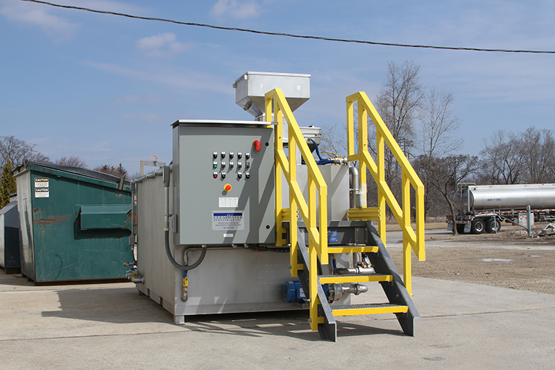 Le système d’abaissement des polymères Clearwater Industries modèle 500 en acier inoxydable est exposé à l’extérieur pour présenter son panneau de commande et l’escalier de l’opérateur.