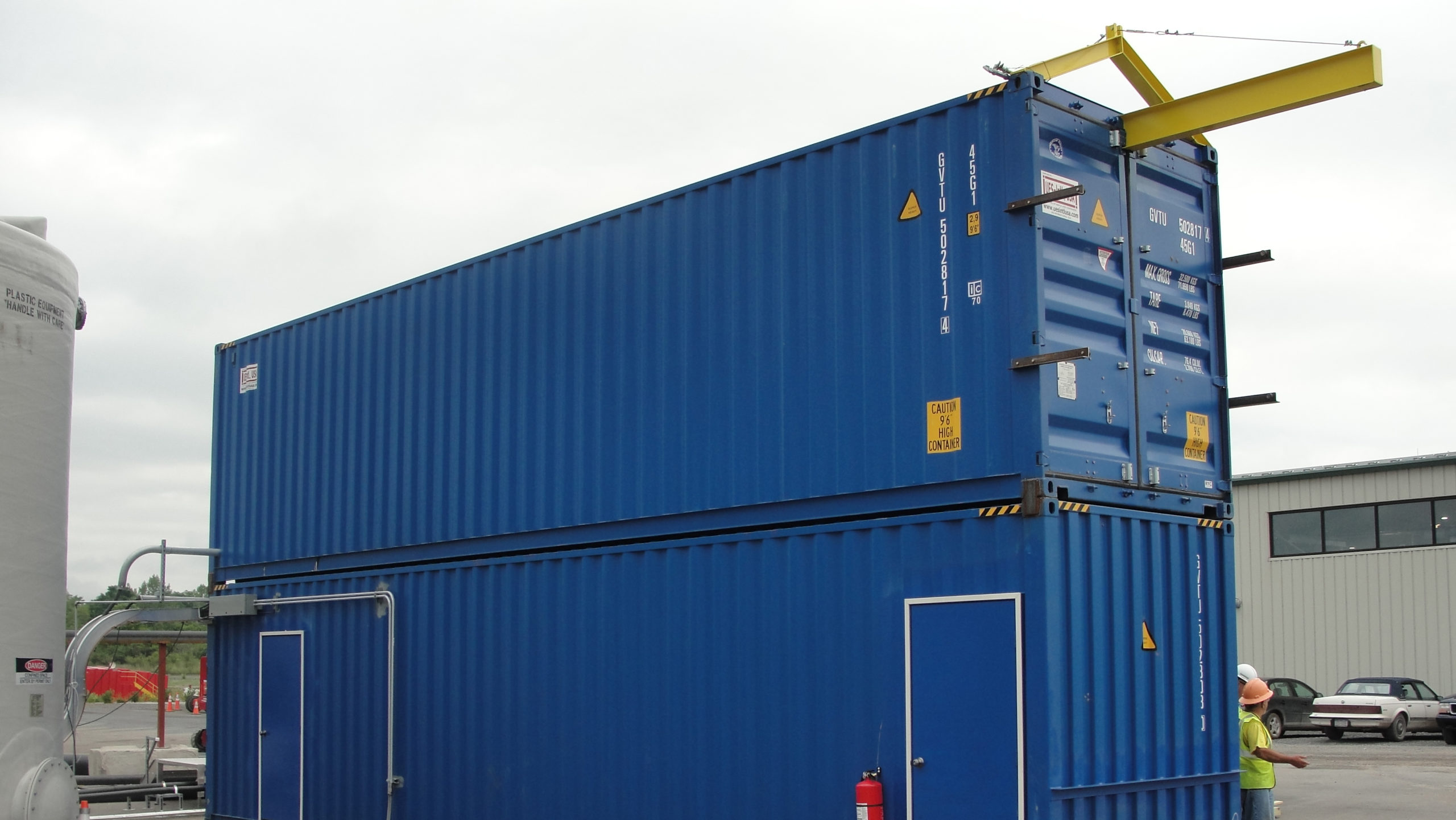 Two shipping containers stacked on top of each other and connected to house a dry polymer preparation system for a dredging project.
