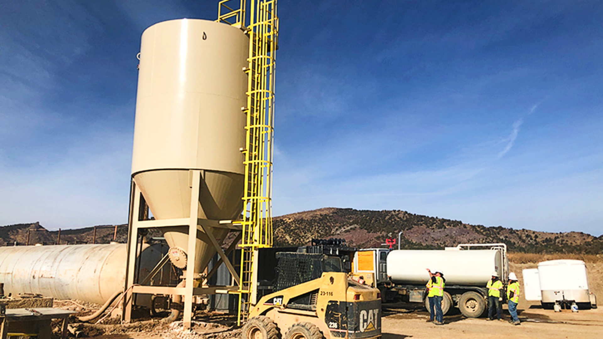 Clearwater high compaction vertical slurry thickener at a job site in southern Colorado with heavy equipment and workers standing around.
