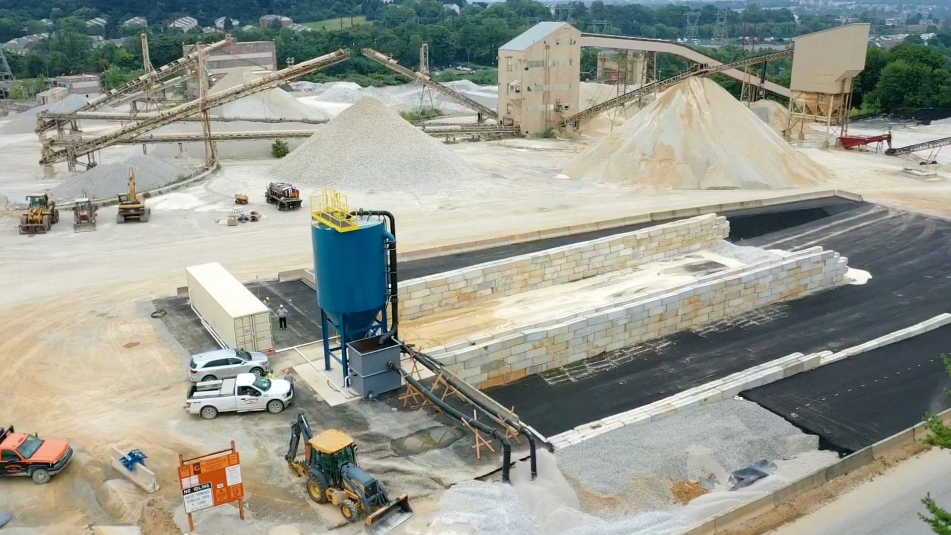 An aggregate production site with gravel piles, a clarifier and mud cells.