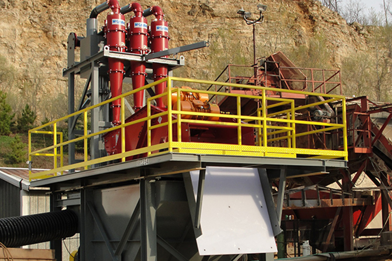 A fines recovery system outside the red cyclones, shaker screen, and yellow handrails.